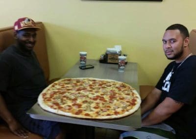 Two men attempting the Brooklyn Pizzeria pizza challenge